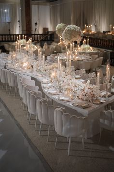 a long table is set with white flowers and candles for an elegant wedding reception at the four seasons hotel