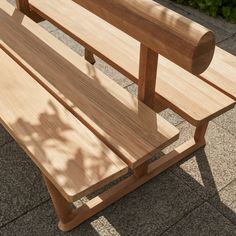 a wooden bench sitting on top of a sidewalk