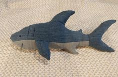 a stuffed shark laying on top of a bed