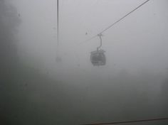 a cable car in the middle of foggy weather with no people on it,