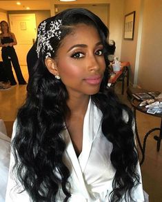 a woman with long black hair wearing a white shirt and headpiece in her hair