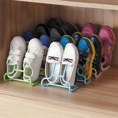 several pairs of shoes are lined up in a closet with hooks on the bottom shelf