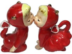 two red ceramic monkeys kissing each other