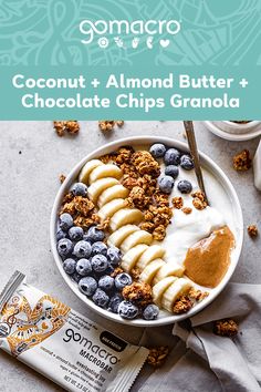 a bowl of granola topped with bananas and blueberries next to a bar of chocolate