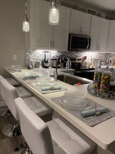 a kitchen with white counter tops and chairs