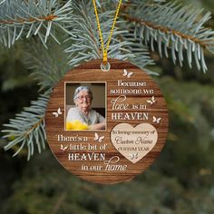 a memorial ornament hanging from a tree with a photo and message on it