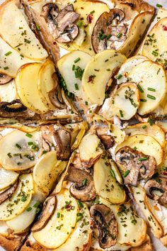 a pizza topped with sliced up potatoes and mushrooms