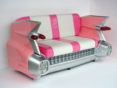 a pink and white couch sitting on top of a table