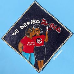 a decorated graduation cap with an image of two women holding a flag and the words we defied this way on it