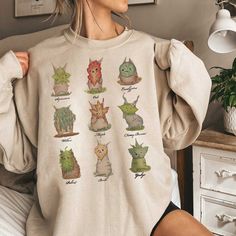 Zelda Korok Sweatshirt, Hylian Shirt, Korok Zelda Plant Shirt, Flora Of Hyrule Shirt, Korok Sweatshirt, Tri Force Shirt, Unisex Clothing Welcome to VEPStore ----- T-shirts ----- For Solid Colors : We Use Gildan 5000 Or Gildan 2000 Tee To Print The Design. They Are 100% Cotton Except Ash - 99% Cotton And 1% Polyester, For Heather Colors We Use Bella Canvas Tee To Print The Design. They Are 52% Cotton, 48% Polyester (Athletic Heather And Black Heather Are 90% Cotton, 10% Polyester) ----- Hoodie -- Long Sleeve Cartoon Print Relaxed Fit Shirt, Relaxed Fit Long Sleeve Shirt With Cartoon Print, Green Long Sleeve Cartoon Print Top, Long Sleeve Cotton Shirt With Character Print, Green Long Sleeve Top With Cartoon Print, Long Sleeve T-shirt With Character Print In Relaxed Fit, Relaxed Fit Long Sleeve T-shirt With Character Print, Casual Long Sleeve Tops With Character Print, Cute Long Sleeve Shirt With Cartoon Print