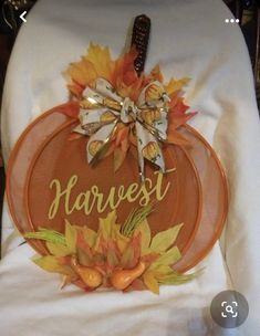 a white chair with an orange pumpkin on it and the words harvest written in gold