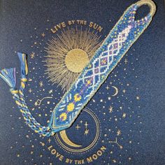 a cross stitch bookmark with the words live by the sun and love by the moon