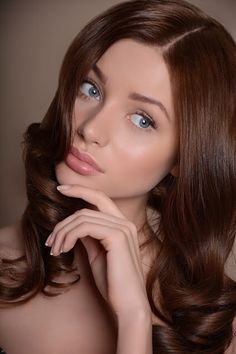 a woman with long hair posing for the camera