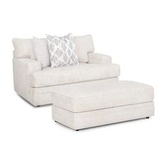 a white chair and ottoman with pillows on it