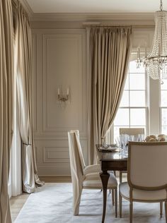 an elegant dining room with chandelier and curtains