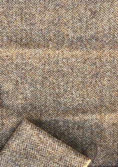 a close up view of a brown and tan tweed fabric with two rows of herrings