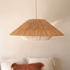 a bed with pillows and a lamp hanging from the ceiling