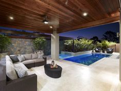 an outdoor living area with couches and a pool