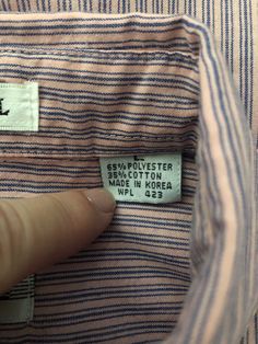 "Vintage Men's 90's Levi's, Big E, Silver Label, Pink, Striped, Short Sleeve, Shirt (XL) 5315 This Men's Levi's Shirt comes in pink cotton/polyester blend with a striped print in purple, short sleeves, two chest pockets with seven front button closure, and button down collar. The fabric is medium weight, does not stretch and has a matte surface. 55% Polyester 35% Cotton Made in Korea *This shirt is from the 90's and measures an XL in todays standards. *This shirt is in excellent condition. Size: 90s Style Cotton Shirt For Spring, 90s Cotton Tops With Button Closure, 90s Style Cotton Tops With Button Closure, Mens 90s, Levis Shirt, Striped Short Sleeve Shirt, Striped Short, Button Down Collar, Levis Men