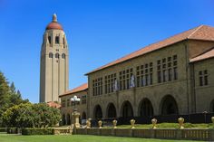 a large building with a clock tower in the middle of it's front yard