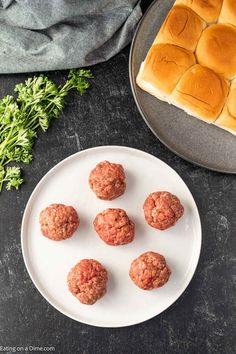 mini meatballs on a plate next to a bun and bread roll with parsley