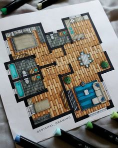 a drawing of a floor plan on top of a sheet of paper next to markers