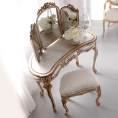 there is a vanity table with two chairs and a mirror on the wall next to it