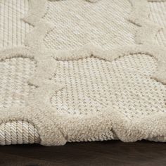 a close up view of a white rug on a wooden floor