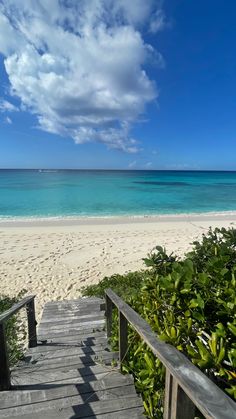 stairs lead down to the beach with clear blue water