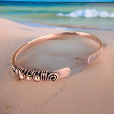 Women's bohemian copper bangle wire wrapped and antiqued to a rustic patina finish. These tribal style copper bracelets make excellent anniversary gifts. Handmade from hammered 10 gauge copper wire. These bracelets can be stacked with other bangles for a great mixed look. Stack as many as you like! This bangle is wire wrapped with 18 gauge copper wire. Makes a great gift for her! It features three wire wrap copper beads and is slightly adjustable. Copper jewelry is always a nice sentimental 7th Bohemian Adjustable Copper Bracelets, Bohemian Copper Bangle As A Gift, Bohemian Copper Bangle For Gifts, Adjustable Hand Forged Bronze Bracelets, Adjustable Bronze Bohemian Bracelets, Bohemian Copper Bangle Jewelry, Bohemian Adjustable Wire Wrapped Bangle, Hand Wrapped Bronze Bohemian Bracelet, Bohemian Copper Bangle