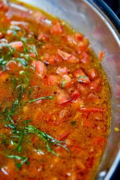 a pot filled with red sauce and vegetables