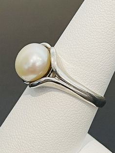 This is a classic and timeless look. Pearls have become en vogue again and this is a ring that would appeal to most women. Great for work or everyday. This ring is made in sterling silver and is a size 8. This pearl is 10 mm. Classic White Pearl Open Ring, Classic White Oval Dome Ring, Minimalist Polished Pearl Ring For Anniversary, Classic Adjustable Ring With Open Band, Silver Sterling Silver Pearl Ring With Polished Finish, Classic White Gold Jewelry Stamped 925, Elegant Adjustable Silver Dome Ring, Elegant Sterling Silver Dome Ring Gift, Sterling Silver Open Pearl Ring With Polished Finish