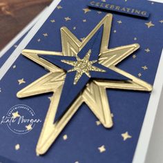 a blue and gold christmas card with a golden star on the front that says celebrating