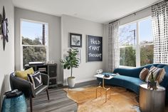 a living room filled with furniture and large windows