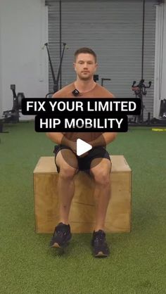 a man sitting on top of a wooden bench in front of a gym equipment rack