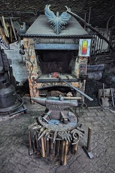 an old fashioned stove with many tools in it's center and on the floor