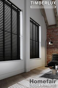 a living room filled with furniture and windows covered in black blindes next to a brick wall