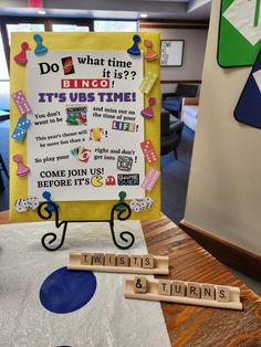 a bulletin board sitting on top of a table next to two wooden letters that say do what time it is