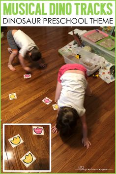 two toddlers playing with musical dino tracks on the floor and in front of them