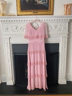 This dress is from the 1960's/70's and is in great vintage condition. The zipper and hook & eyes are all functional. The accordion pleated tiers add such a special touch! Under each pleat is solid pink satin fabric. The top pleat is a cape that covers the shoulders.  Measurements: Bust: 34" Waist- 27" Hip- 34" Length from top of shoulders to hem- 57" Pink Accordion Pleats Skirt, Pink Pleated A-line Maxi Dress, Pink Voluminous Pleated Maxi Skirt, Pink Satin Fabric, 1970s Pink Long Sleeve Dress, 1968 Pink & Orange Dress, Pleated Gown, Pink Satin, Satin Fabric