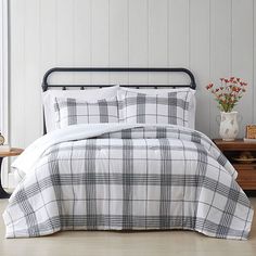 a white and black plaid comforter set on a bed