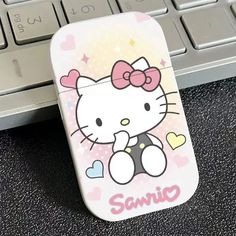 a hello kitty cell phone case sitting on top of a computer keyboard with the word sanrio printed on it