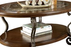 a wooden table topped with a bowl of fruit on top of a glass shelf next to books