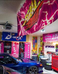 a car showroom filled with cars and colorful banners hanging from the ceiling above them