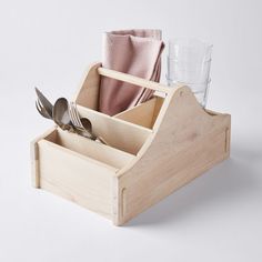 a wooden holder with utensils and spoons in it on a white background