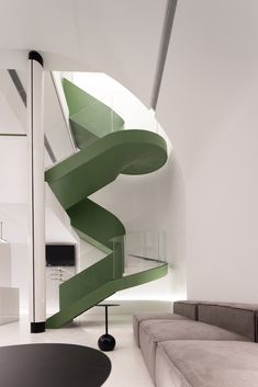 a living room with a spiral staircase next to a couch