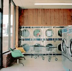 a laundry room with washing machines and chairs