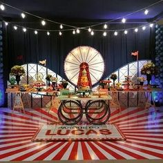 a carnival themed birthday party with ferris wheel and candy buffet table set up in front of an american flag backdrop