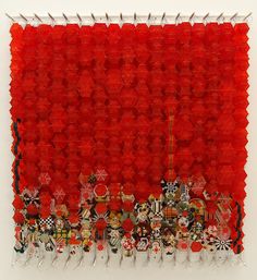 an art work made out of red plastic cups and magnets on a white wall