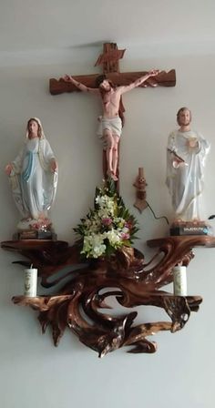 the crucifix is made out of wood and has flowers in front of it